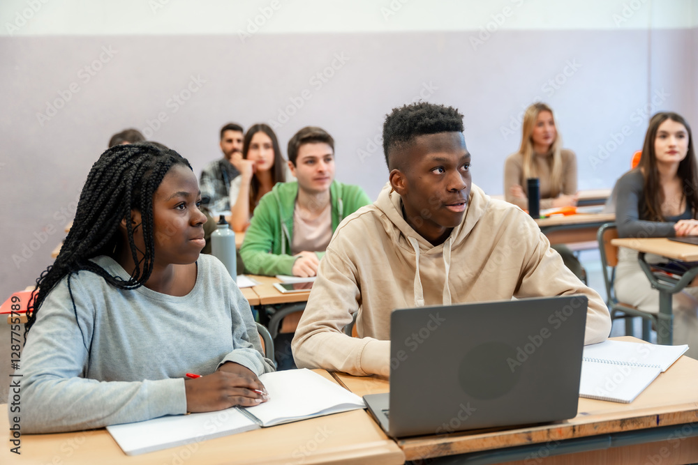 University students learning in classroom using laptop and notebook University students learning in classroom using laptop and notebook