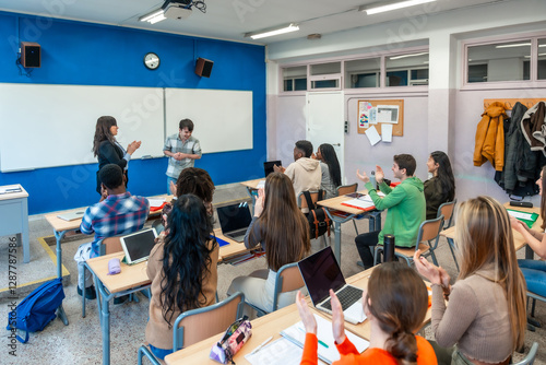 Students clapping in university classroom after presentation of shy student