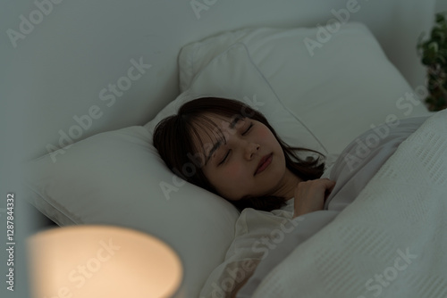 ベッドで眠る若い女性