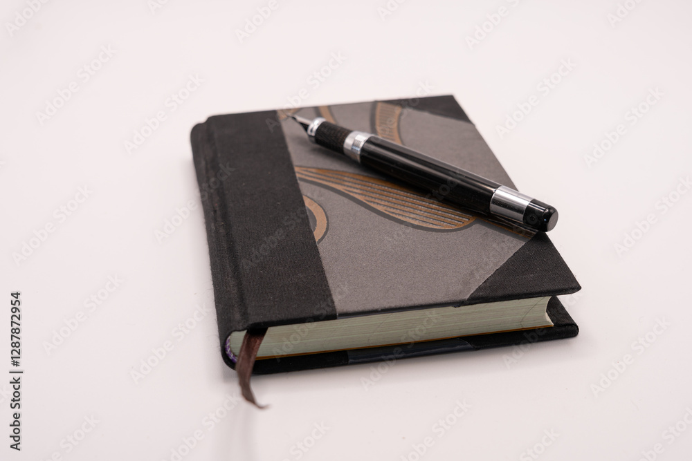 A black pen with a customized notebook isolated on white background