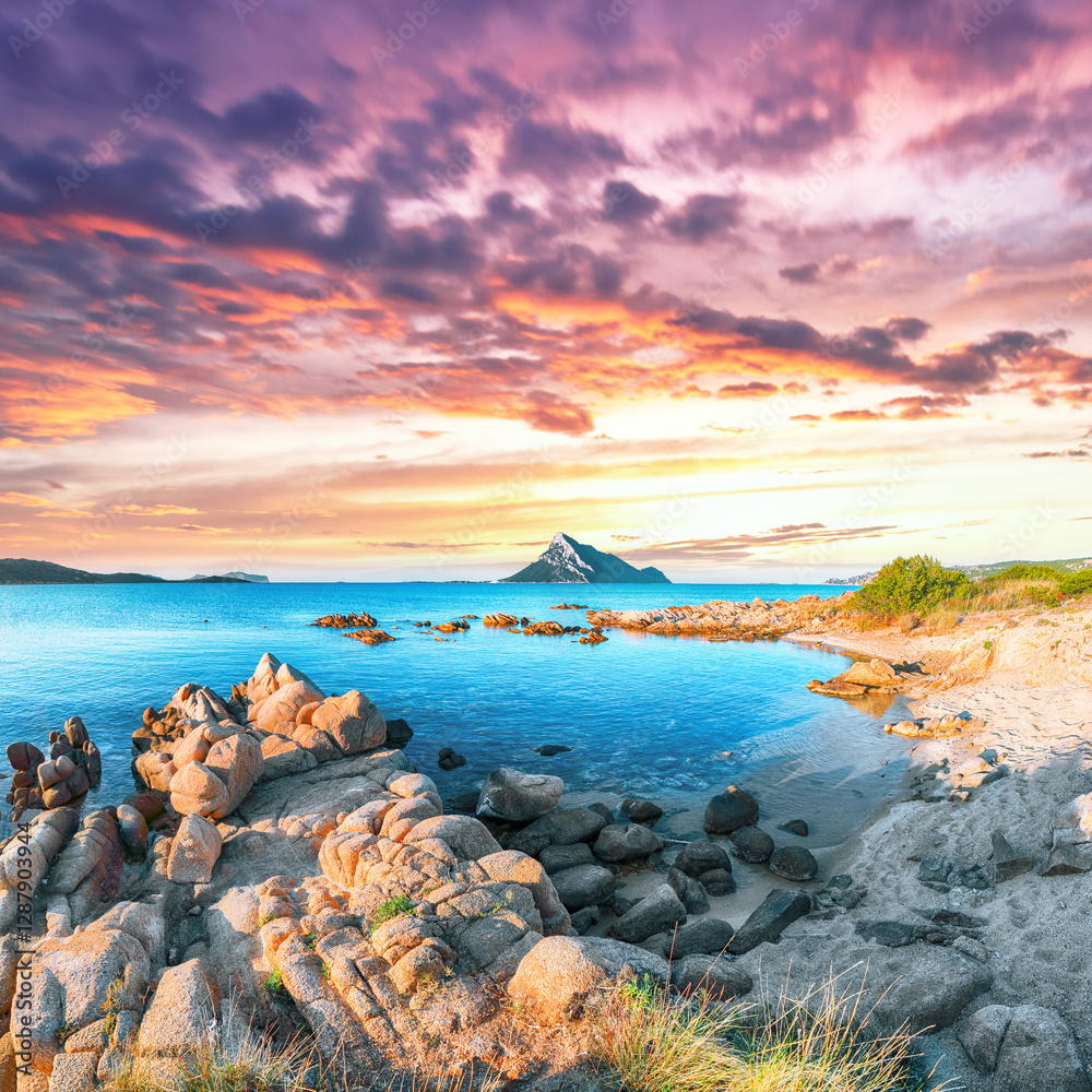 Superb evening scene of Porto Taverna beach with Tavolara mountain on background.