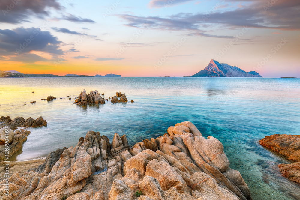 Superb evening scene of Porto Taverna beach with Tavolara mountain on background.