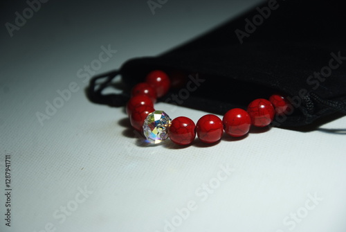 Bracelet in a black jewelry pouch. Exclusive red howlite bracelet with crystal