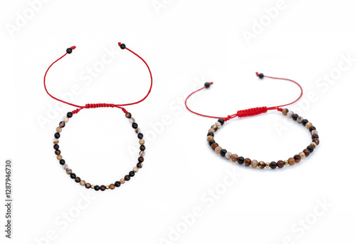 Obraz na płótnie Two Bracelets on Red Cord with Shamballa Knot, Agates, and Tiger's Eye on White Background w salonie