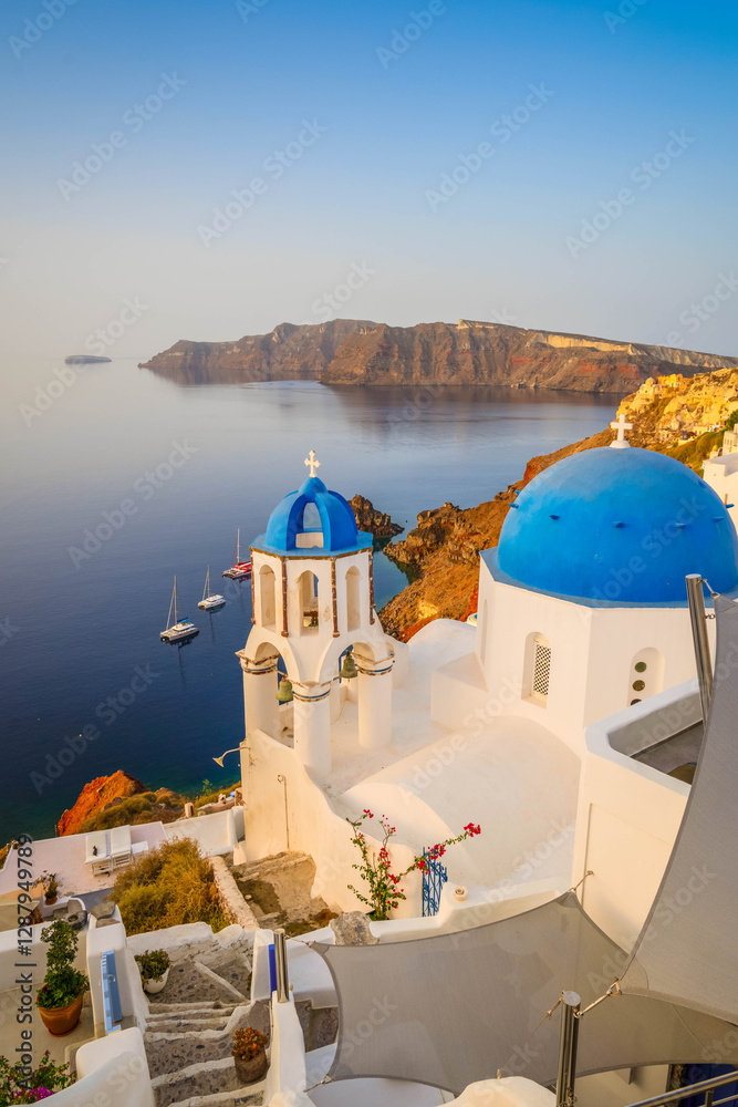Obraz premium street of traditional greek village Oia of Santorini, with blue domes against Aegan sea and caldera, Greece, web banner format