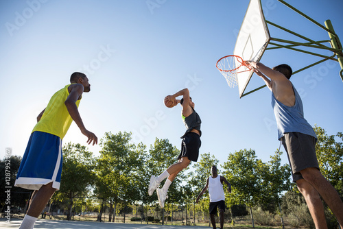 Group of people running and jumping while playing streetball photo