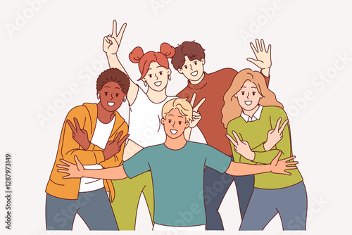 Group of multiracial students pose for group photo showing positive emotions and V gestures. Diverse young men with girls smiling and looking at screen demonstrate joy and togetherness.