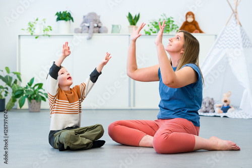 Baby Sign Language. Nonverbal child learning to sign with the help of a speech therapist. Child therapy, neurodiversity, learning difficulty, developmental disability.