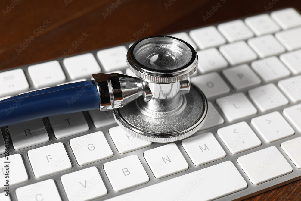 Technical support concept. Stethoscope and keyboard on wooden table, closeup Technical support concept. Stethoscope and keyboard on wooden table, closeup