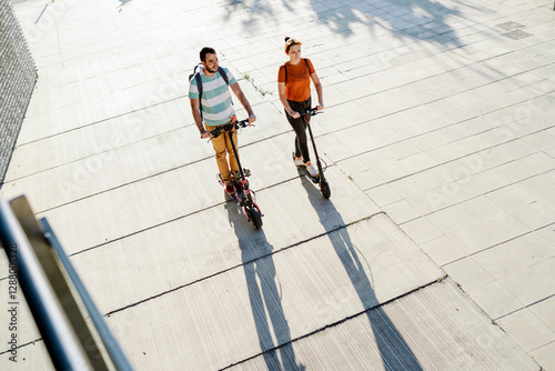 Wallpaper Mural Couple with backpacks riding electric scooters Torontodigital.ca