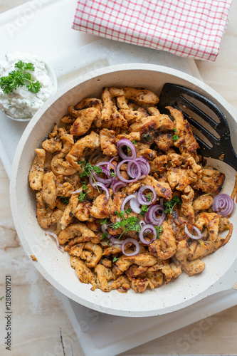 Tasty chopped and pan fried chicken breast with delicious greek spices, gyros style served ready to eat in frying pan.