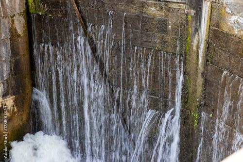 a leaking old wooden dam with a lot of holes