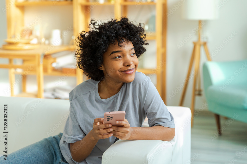 African girl holding smartphone touch screen typing scroll page at home. Woman with cell phone surfing internet using social media apps playing game. Shopping online Internet news cellphone addiction