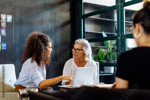 Businesswomen with laptop working together in loft office