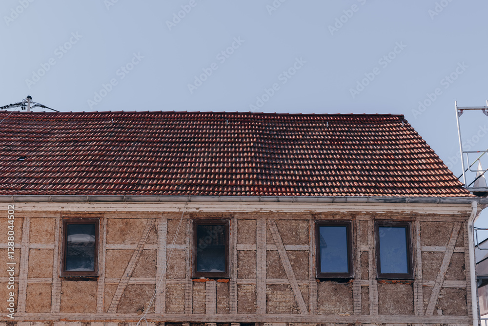 Renovation work on historic building with red tile roof underway in sunny weather Renovation work on historic building with red tile roof underway in sunny weather