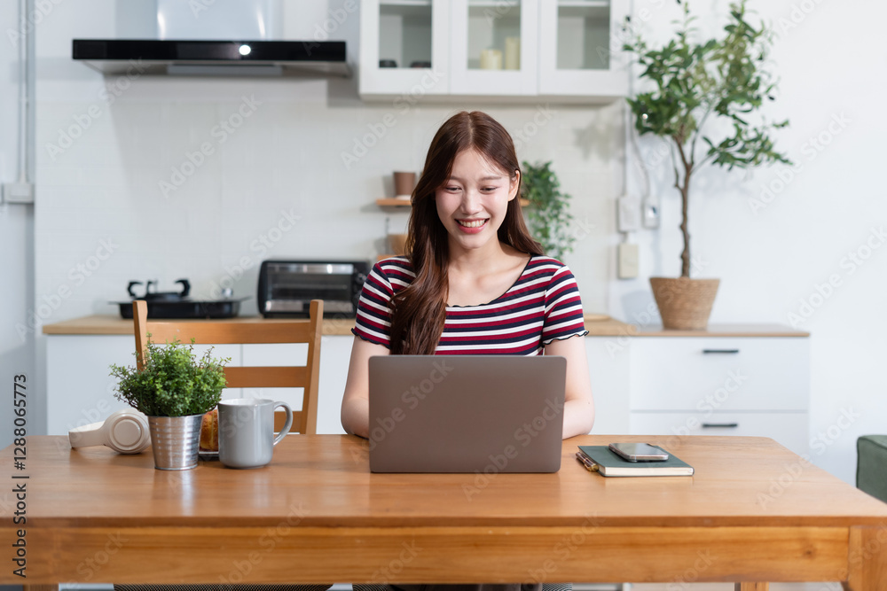 Lifestyle people, using computer working online, doing searching, sitting in the kitchen. Lifestyle people, using computer working online, doing searching, sitting in the kitchen.
