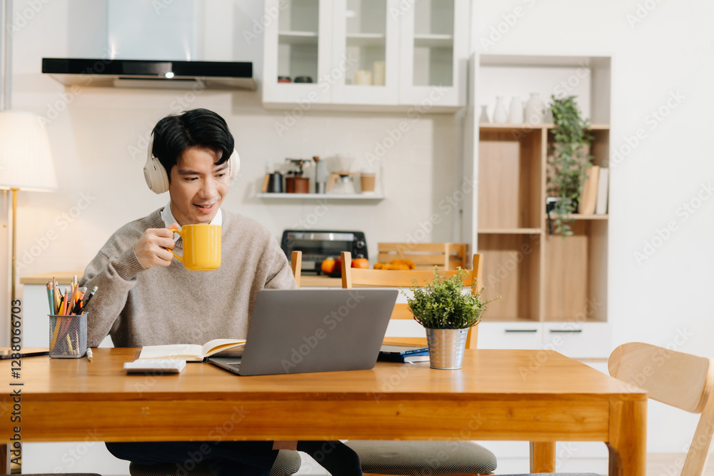 Lifestyle people, using laptop computer and smartphone and enjoys a coffee sitting in the kitchen. Lifestyle people, using laptop computer and smartphone and enjoys a coffee sitting in the kitchen.