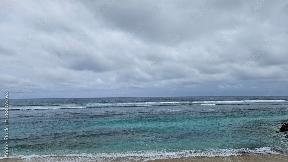 Scenic view of a calm ocean with gentle waves under a cloudy sky, creating a serene and tranquil atmosphere Scenic view of a calm ocean with gentle waves under a cloudy sky, creating a serene and tranquil atmosphere