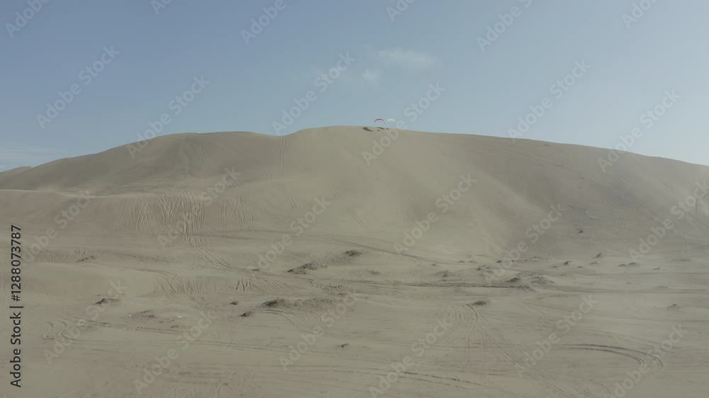 Paragliders resting, showcasing an aerial view of vast sand dunes Paragliders resting, showcasing an aerial view of vast sand dunes