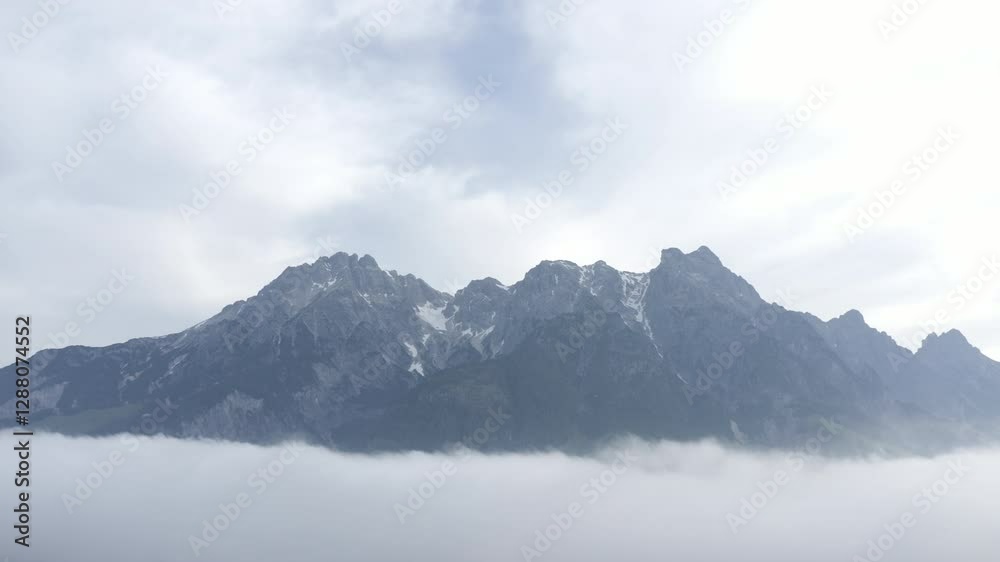 Majestic mountain peaks in Austria with clouds below, a peaceful and natural scene Majestic mountain peaks in Austria with clouds below, a peaceful and natural scene