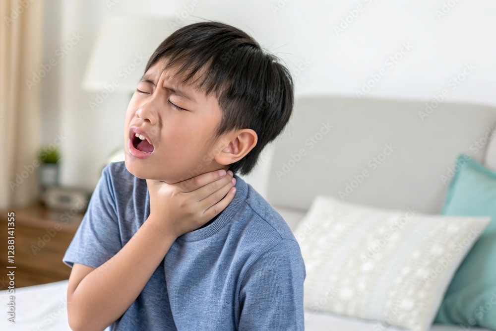 A young boy feeling discomfort, holding his throat, expressing distress at home. Emotional health awareness. A young boy feeling discomfort, holding his throat, expressing distress at home. Emotional health awareness.