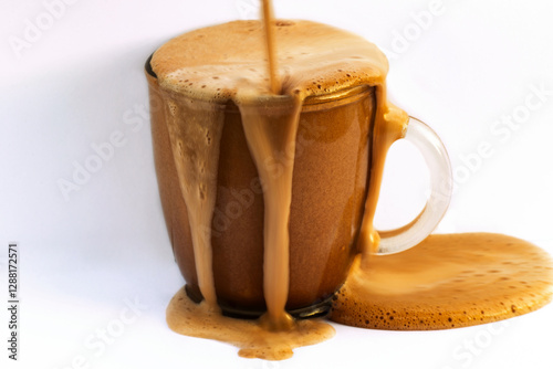 Wallpaper Mural Hot foamy chocolate overflows on glass and on light background. Torontodigital.ca