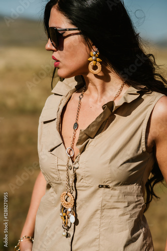 close up view of beautiful woman in dress holding necklace and bijoux