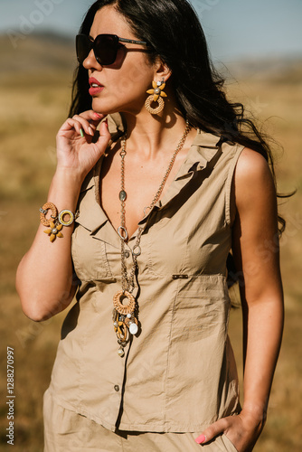 close up view of beautiful woman in dress holding necklace