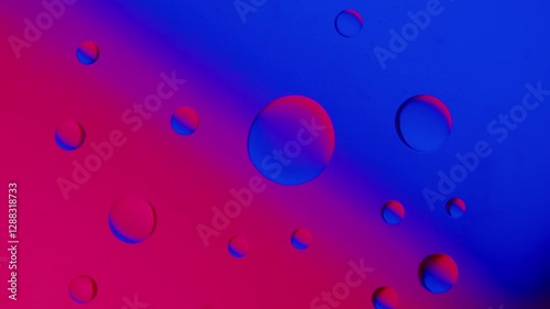 a large drop connects with a smaller drop on a blue-red gradient background. High resolution footage 4k.