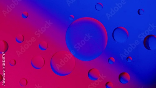 a small drop connects with another larger drop on a blue and red gradient background. High resolution footage 4k.