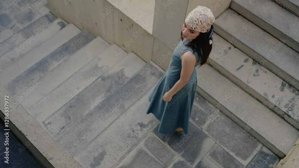 Stylish woman in a blue dress and headscarf standing on a rustic stone staircase, looking back. Captures elegance and vintage style. Fashionable Woman in Blue Dress and Headscarf on Stone Staircase Stylish woman in a blue dress and headscarf standing on a rustic stone staircase, looking back. Captures elegance and vintage style. Fashionable Woman in Blue Dress and Headscarf on Stone Staircase