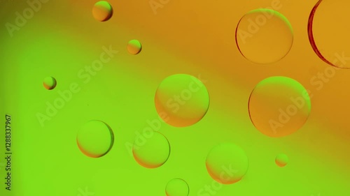 merging drops on yellow-green gradient background. High resolution footage 4k.