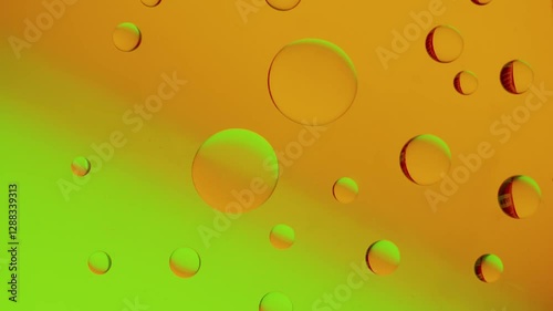 drops connect with others on a yellow-green gradient background. High resolution footage 4k.