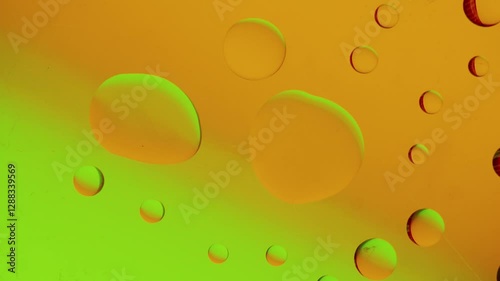 a large drop connects with a smaller drop on a yellow-green gradient background. High resolution footage 4k.