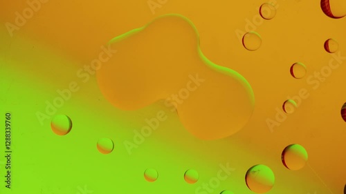 several drops join together on a yellow-green gradient background. High resolution footage 4k.