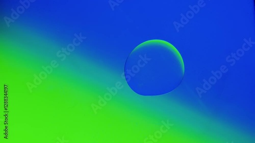 Two drops connect together on a blue-green gradient background. High resolution 4k video.