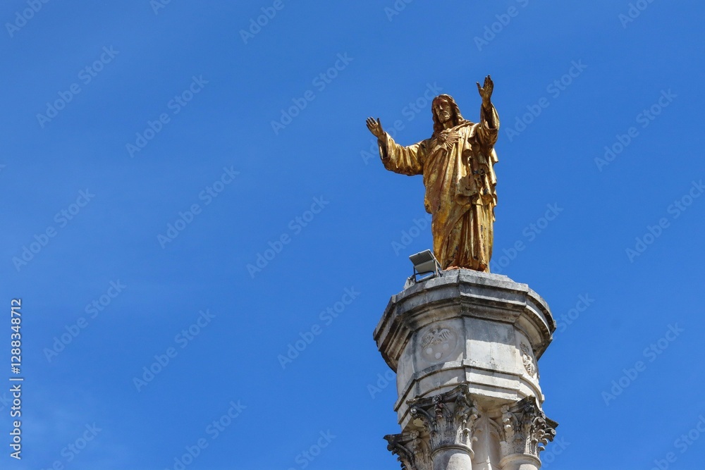 Golden Jesus statue against blue sky in Lourdes. Golden Jesus statue against blue sky in Lourdes.