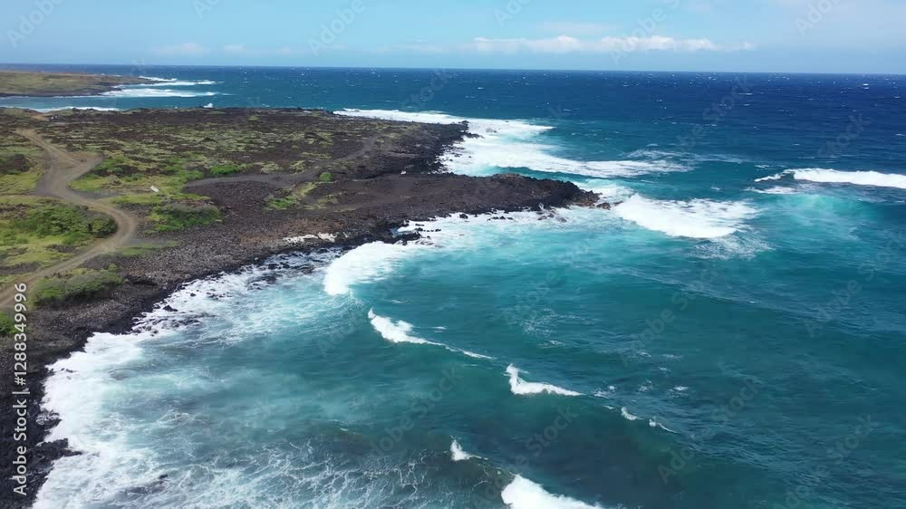 An aerial view of waves crashing against the volcanic shoreline near Green Sands Beach, Hawaii. The rugged coastline meets the deep blue Pacific Ocean in a stunning seascape. An aerial view of waves crashing against the volcanic shoreline near Green Sands Beach, Hawaii. The rugged coastline meets the deep blue Pacific Ocean in a stunning seascape.
