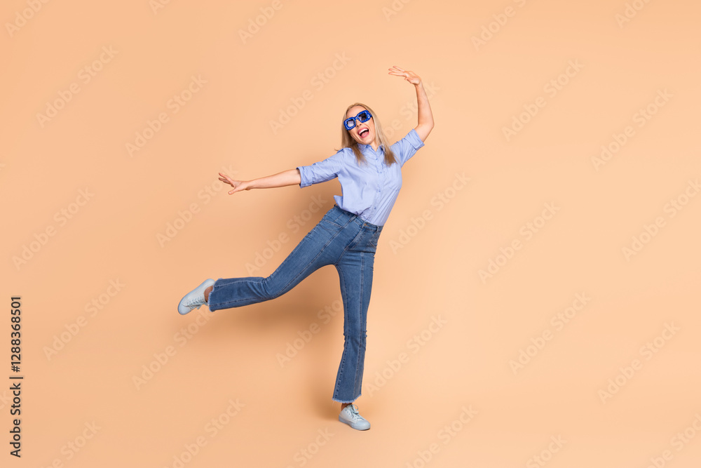 Smiling woman in stylish casual attire posing against a pastel beige background, exuding confidence and charm Smiling woman in stylish casual attire posing against a pastel beige background, exuding confidence and charm