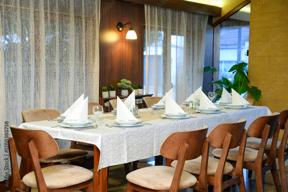 Fototapeta premium February 23, 2025 - Belgrade, Serbia. Restaurant interior with set dining utensils.