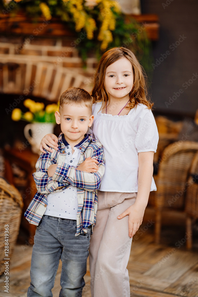 Fototapeta premium Little brother and sister hugging in the interior of a country house.