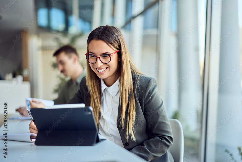 Young Business Professional Using a Tablet in a Bright Office Environment Young Business Professional Using a Tablet in a Bright Office Environment