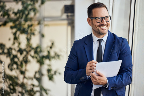 Businessman Smiling at Work Holding Documents, Professional Office Background photo