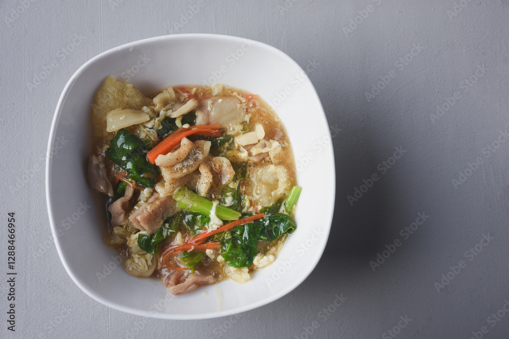 Stir-fried noodles with pork and kale, served with pork on top. Chinese-Thai food, called Stir-fried noodles with pork and kale, served with pork on top. Chinese-Thai food, called