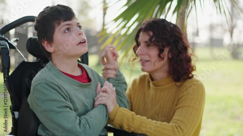 Mother comforting disabled son in wheelchair photo