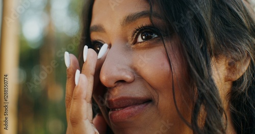 Beautiful african american woman with makeup and hairstyle smiling and wiping tears of happiness photo