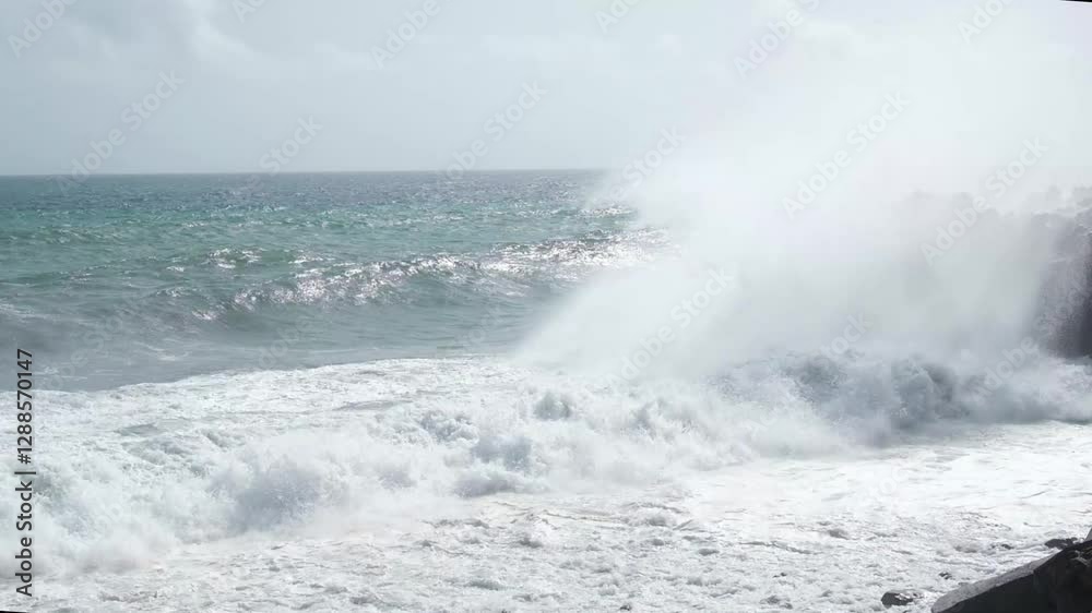 Ocean storm with turquoise waves and foam at tropical coast with black rock Ocean storm with turquoise waves and foam at tropical coast with black rock