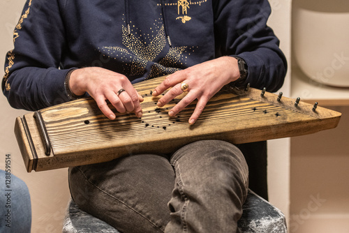 Tableau sur toile Fingers of a girl playing kankles, Lithuanian plucked string instrument belongin