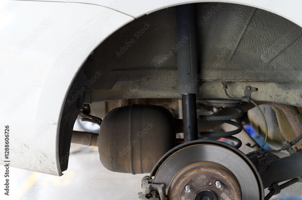 Shock absorber broken. Close up of car rear suspension system, showing shock absorber, coil spring, and brake disc Shock absorber broken. Close up of car rear suspension system, showing shock absorber, coil spring, and brake disc