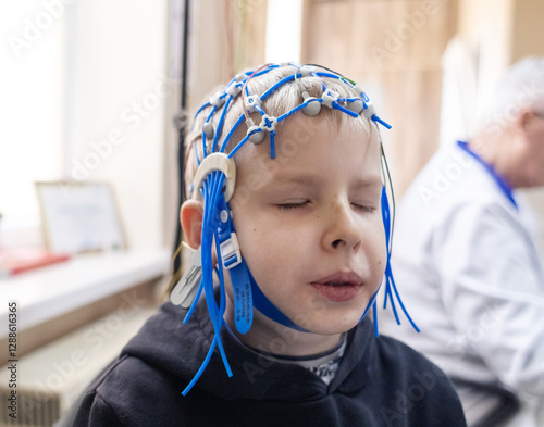 A boy's brain is examined on an EEG machine. Electroencephalogram is performed in a hospital laboratory to detect neurological diseases. Encephalogram for children